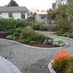 Concrete "mow strips" in this case seperate the planting areas from the blue granite pathways.