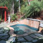 The spa is complemented with a pergola that matches the kitchen design and the flagstone is now insterted in a lawn area for a charming effect.