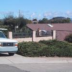 Front entry drive gate has an old juniper.